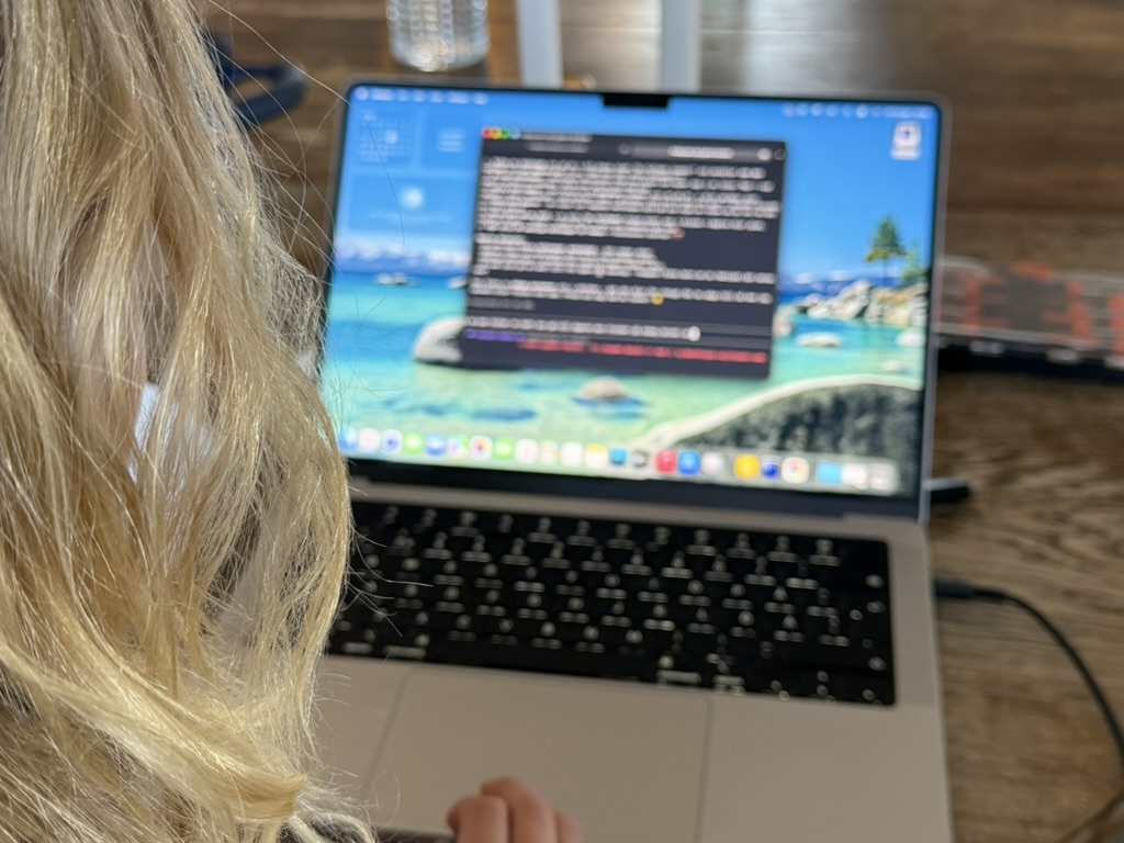 My daughter at the laptop, Claude Code terminal open
